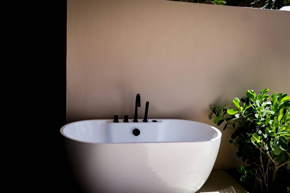 restored claw foot bathtub vintage bathroom with freestanding faucet and subway tile backdrop