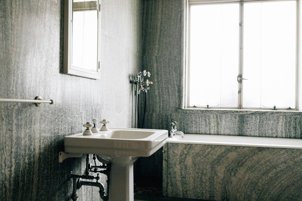 vintage clawfoot tub with polished brass feet and porcelain finish in a sunlit bathroom